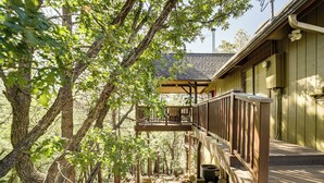 A wooden deck with a railing, surrounded by trees and rocks. - Deck & Scenic Views: Munds Park A-frame Cabin (Munds Park)
