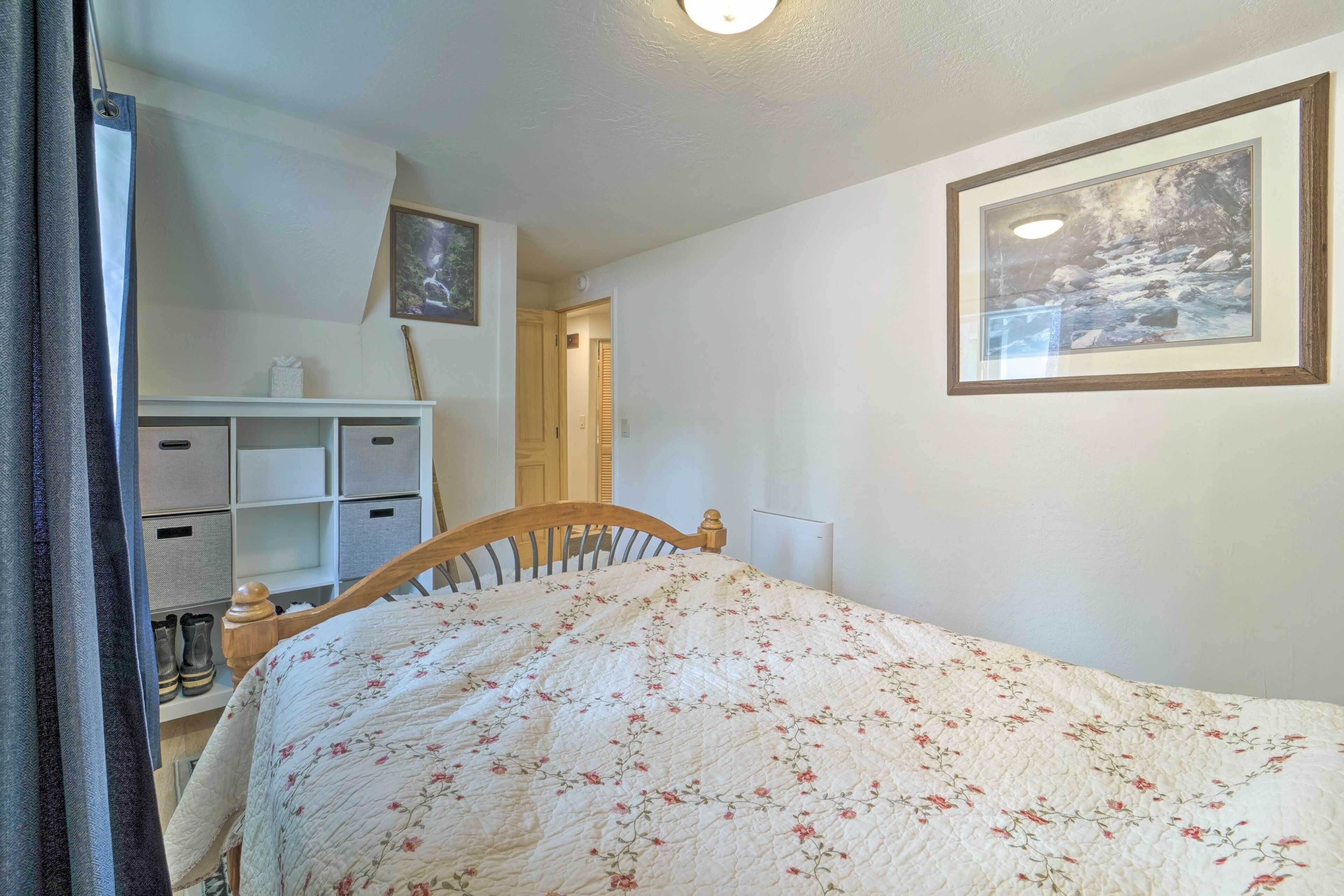 Une chambre à coucher comprenant un lit, une table de chevet, une commode, une armoire et un tableau encadré accroché au mur.