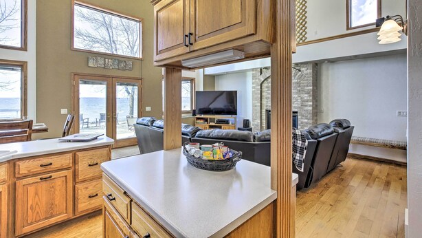 A spacious kitchen with wooden cabinets, a large island, and a dining area.