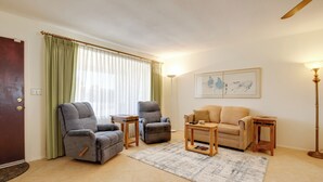 A living room with two grey armchairs, a beige sofa, a wooden coffee table, and a floor lamp. - Patio & Mtn Views: 55 + Apache Junction Home! (Apache Junction)