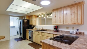A kitchen with wooden cabinets, a black refrigerator, a dishwasher, a stove, and a sink. - Patio & Mtn Views: 55 + Apache Junction Home! (Apache Junction)