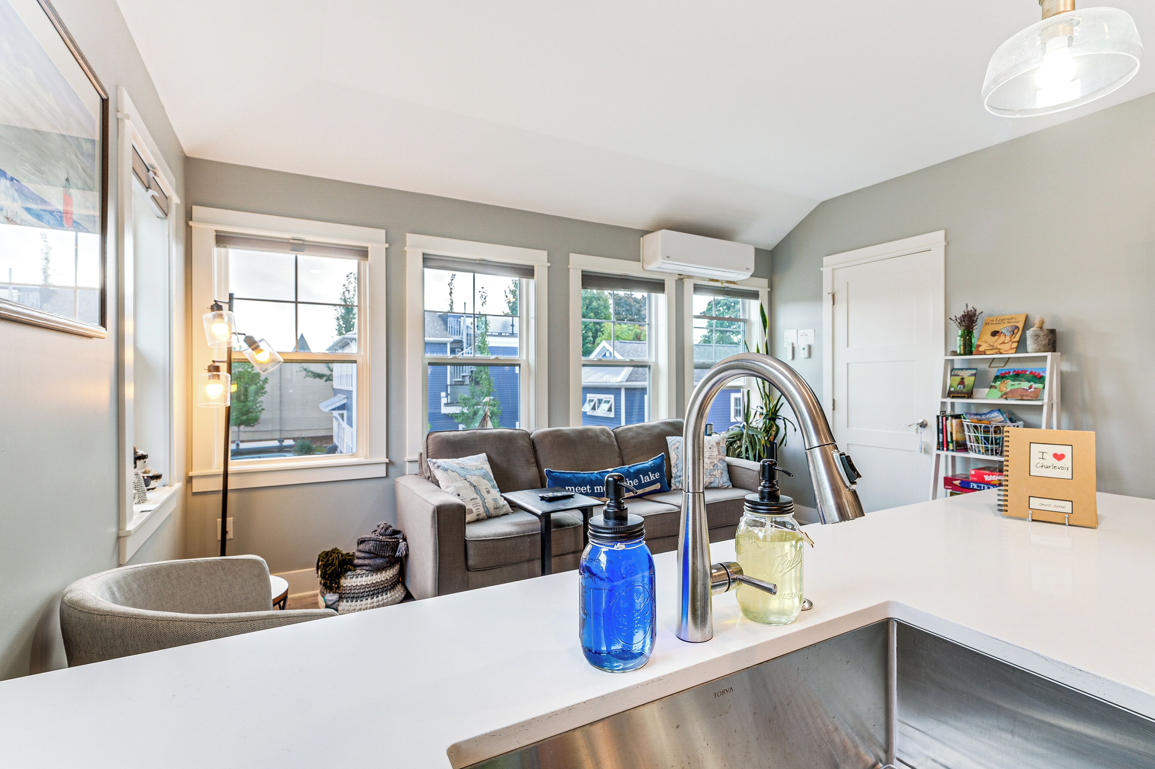 A modern kitchen with a white countertop, a stainless steel sink, and a blue water dispenser.