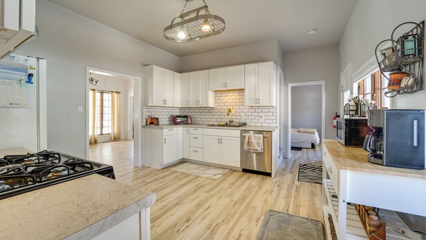 A spacious kitchen with white cabinets, a stainless steel dishwasher, and a gas stove. - 'dolorable' Home w/ Yard - Walk to River! (Dolores)