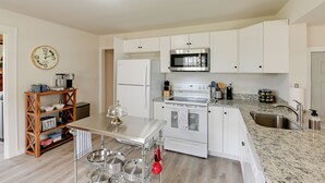 A modern kitchen with white cabinets, a stainless steel refrigerator, a built-in oven, a microwave, and a granite countertop. - Chic Columbia Home < 2 Mi to Historic Square! (Columbia)