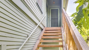 A wooden staircase leading to a green door, surrounded by white siding and a wooden railing. - Central South Pasadena Apt, 3 Mi to Rose Bowl (South Pasadena)