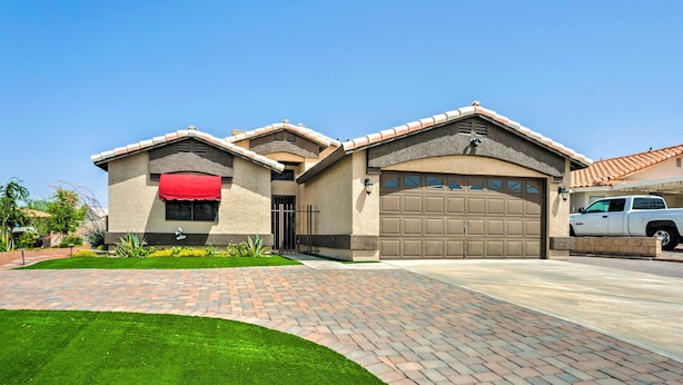 A two-story house with a garage, a driveway, and a well-maintained lawn. - Havasu Vacation Rental w/ Private Pool & Hot Tub! (Lake Havasu City)
