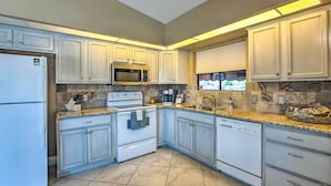 A modern kitchen with white cabinets, granite countertops, a built-in microwave, stove, and dishwasher. - Havasu Vacation Rental w/ Private Pool & Hot Tub! (Lake Havasu City)