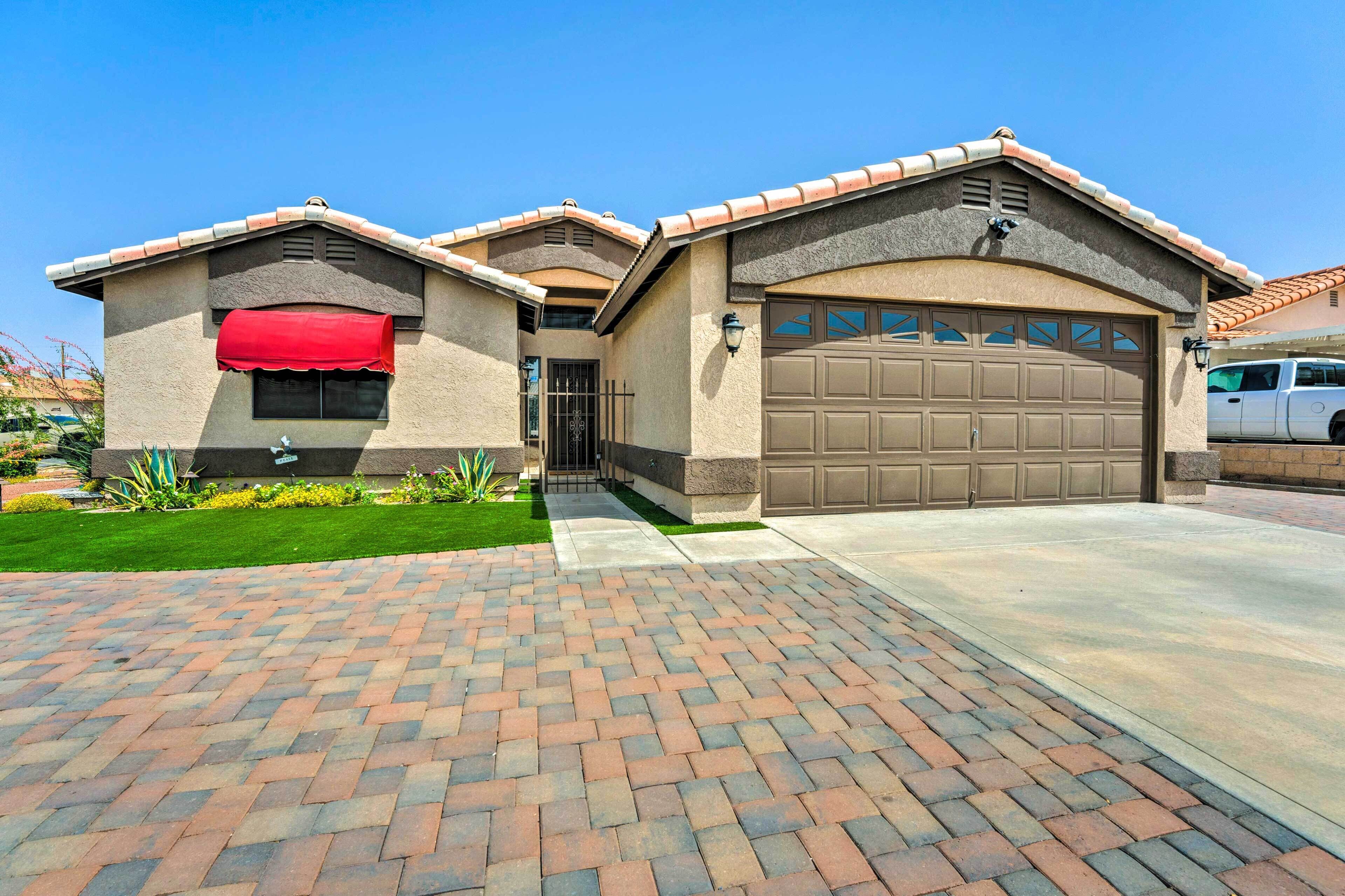 A residential house with a garage, a red awning, and a paved driveway.