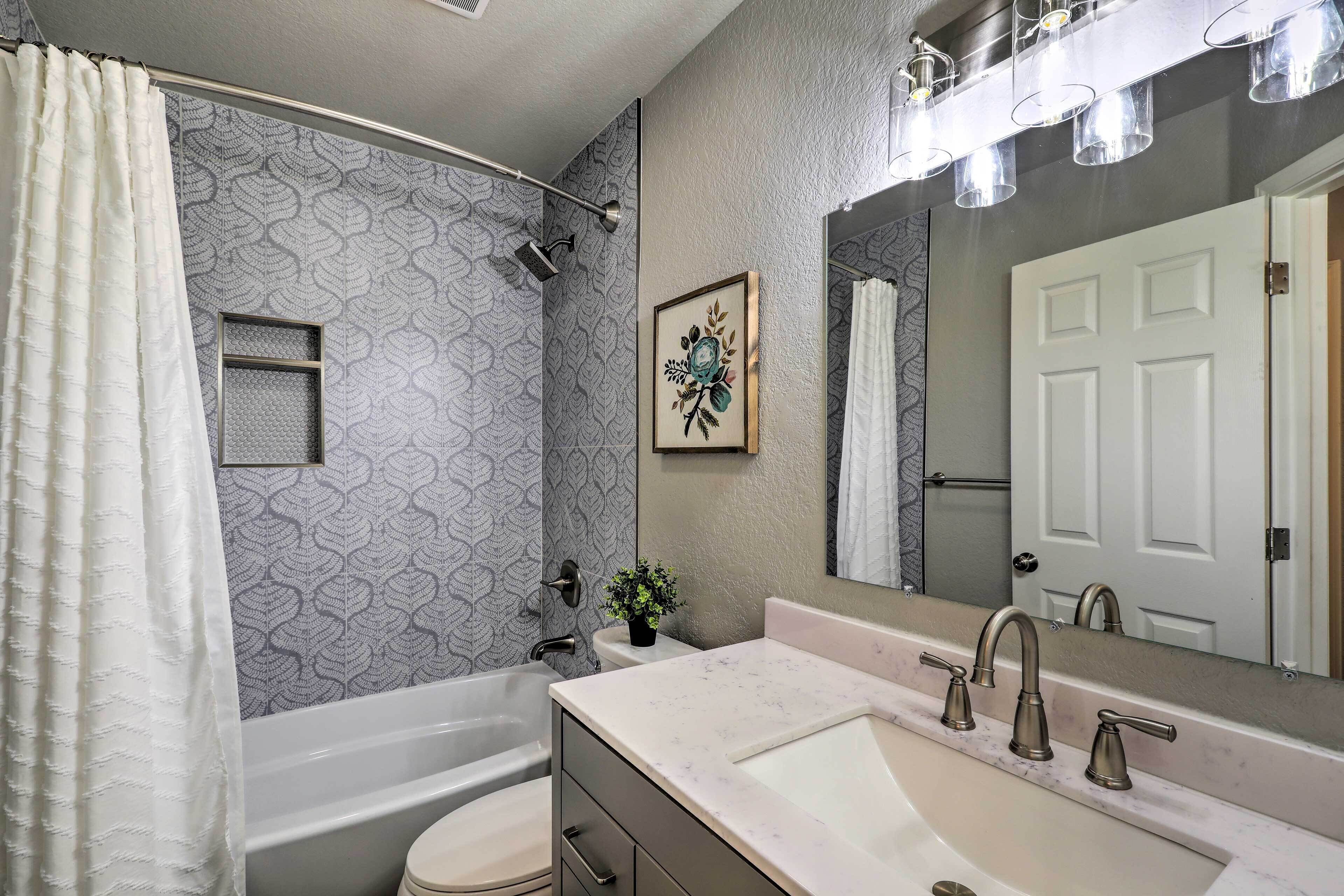 A bathroom with a bathtub, toilet, sink, and a shower.