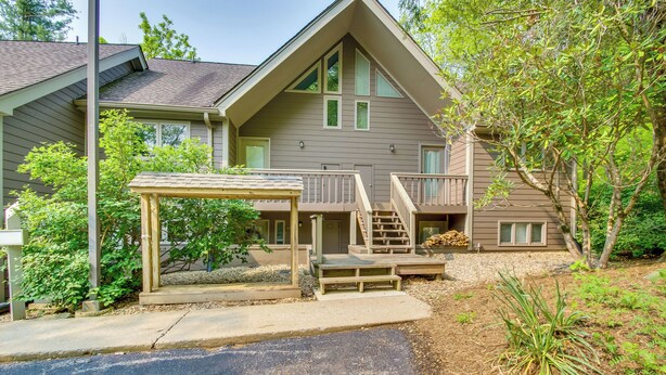 A two-story house with a covered porch, a small deck, and a landscaped garden. - Second-floor Condo w/ Community Pool Access! (Nellysford)
