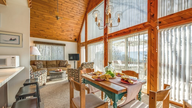 A cozy dining area with a wooden table, chairs, and a television in the background.
