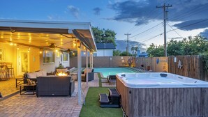 Ein Garten mit Whirlpool, Sitzgelegenheit im Freien und einem Schwimmbecken.