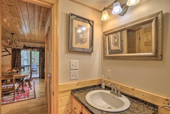 A wooden interior with a dining area, a sink with a mirror, and a chandelier. - Gated Community w/ Perks! Sparta Family Cabin (Sparta)