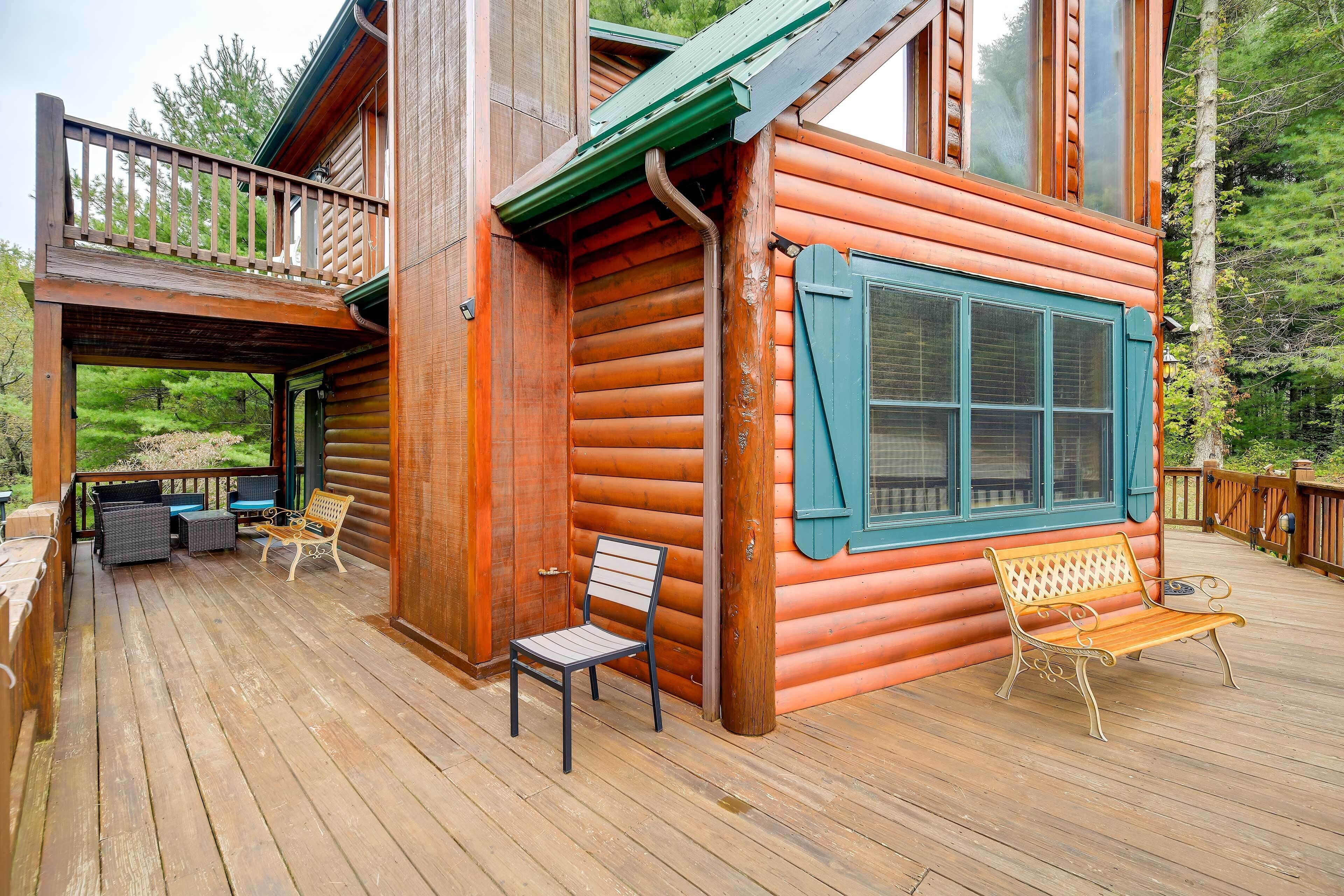 Une cabane en bois avec une terrasse, un banc et une chaise.