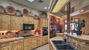A kitchen with wooden cabinets, a black microwave, an oven, and a sink. - Patio, Grill & Yard: Pet-friendly Lake Havasu Gem (Lake Havasu City)
