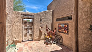 A courtyard with a rustic door, a tiled floor, and a wheelbarrow. - Patio, Grill & Yard: Pet-friendly Lake Havasu Gem (Lake Havasu City)