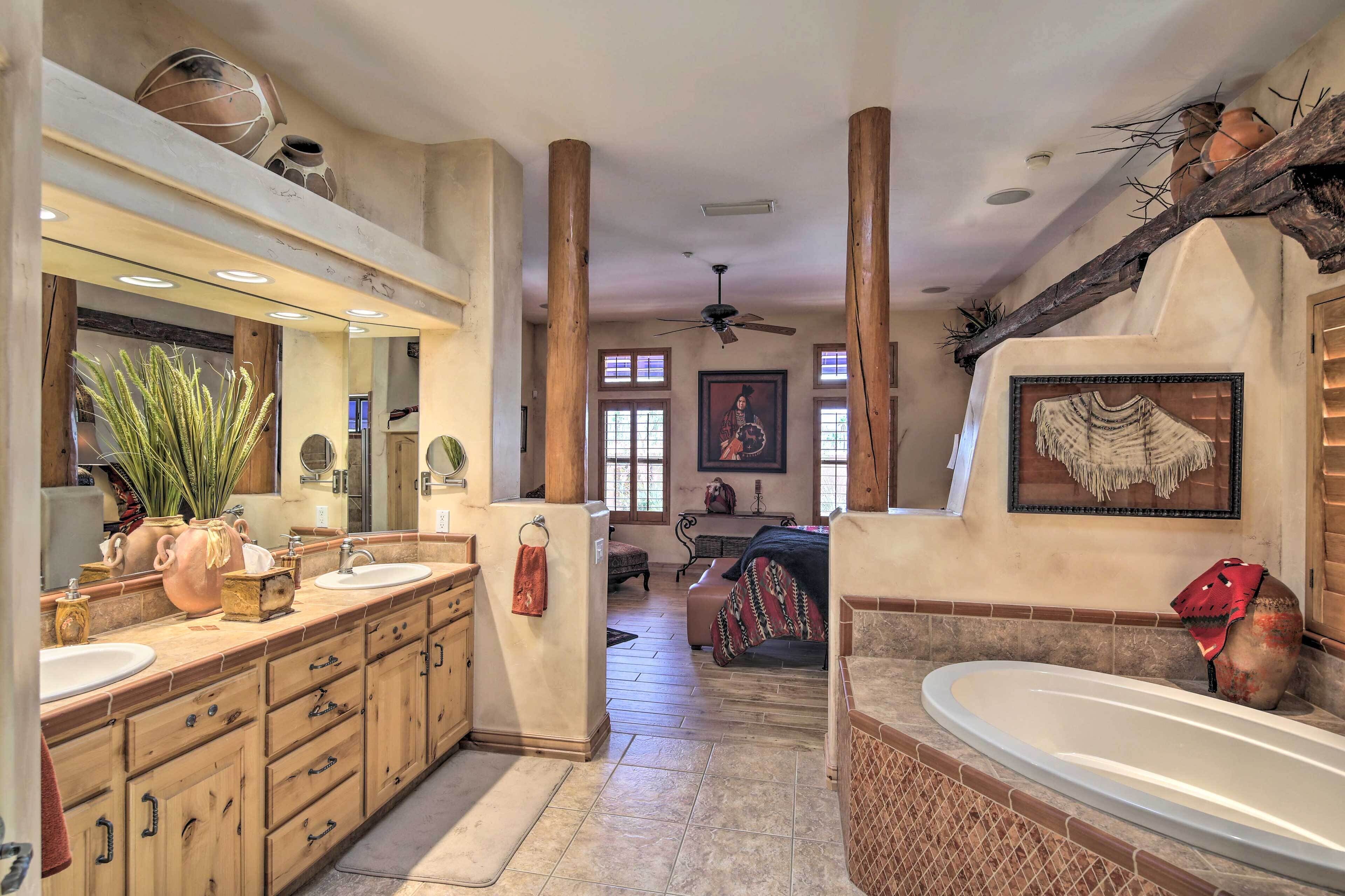 Un baño espacioso con un tocador grande, una bañera y un ventilador de techo.