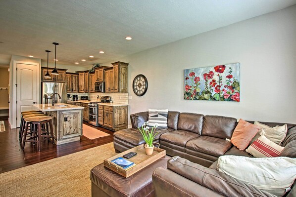 A modern kitchen with wooden cabinets, a central island, and a dining area.