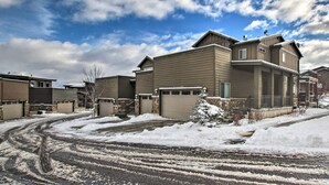 A residential area with houses, a driveway, and snow-covered ground.