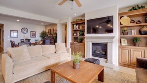A living room with a beige sofa, wooden coffee table, and a fireplace. - Single-story San Bernardino Home w/ Valley Views! (San Bernardino)