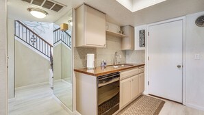 A kitchen with a dishwasher, a sink, and a white door. - Walk to Lake Havasu Beaches: Condo w/ Pool Access! (Lake Havasu City)