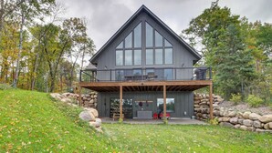 Een modern huis met een ruim balkon, stenen muren en een gazon.