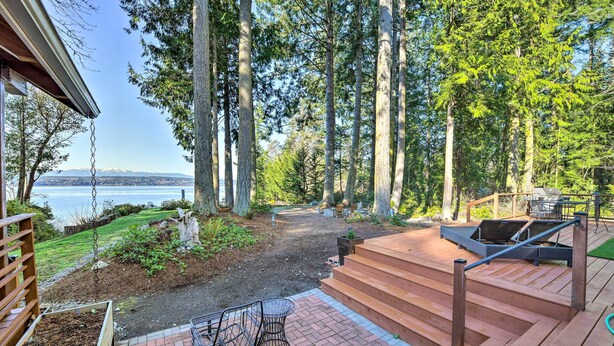 A deck with a view of a lake, surrounded by trees. - Mid-century Cabin w/ Deck & Puget Sound Vistas! (Hansville)