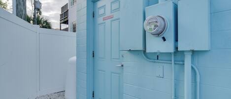 A blue door with a sign reading "ALLEY ROOM" and a utility meter on the wall.
