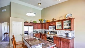 A modern kitchen with wooden cabinets, granite countertops, and stainless steel appliances. - Tucson Home W/pool & Santa Catalina Mtn Views (Tucson)