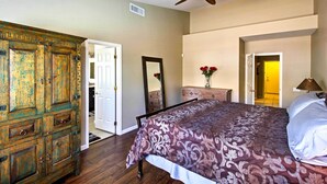 A bedroom with a bed, a ceiling fan, a dresser, and a mirror. - Tucson Home W/pool & Santa Catalina Mtn Views (Tucson)