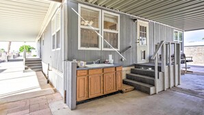 A compact kitchen with wooden cabinets, a sink, and a small countertop. - Cozy Yuma Retreat w/ Furnished Patio & Grill! (Yuma)