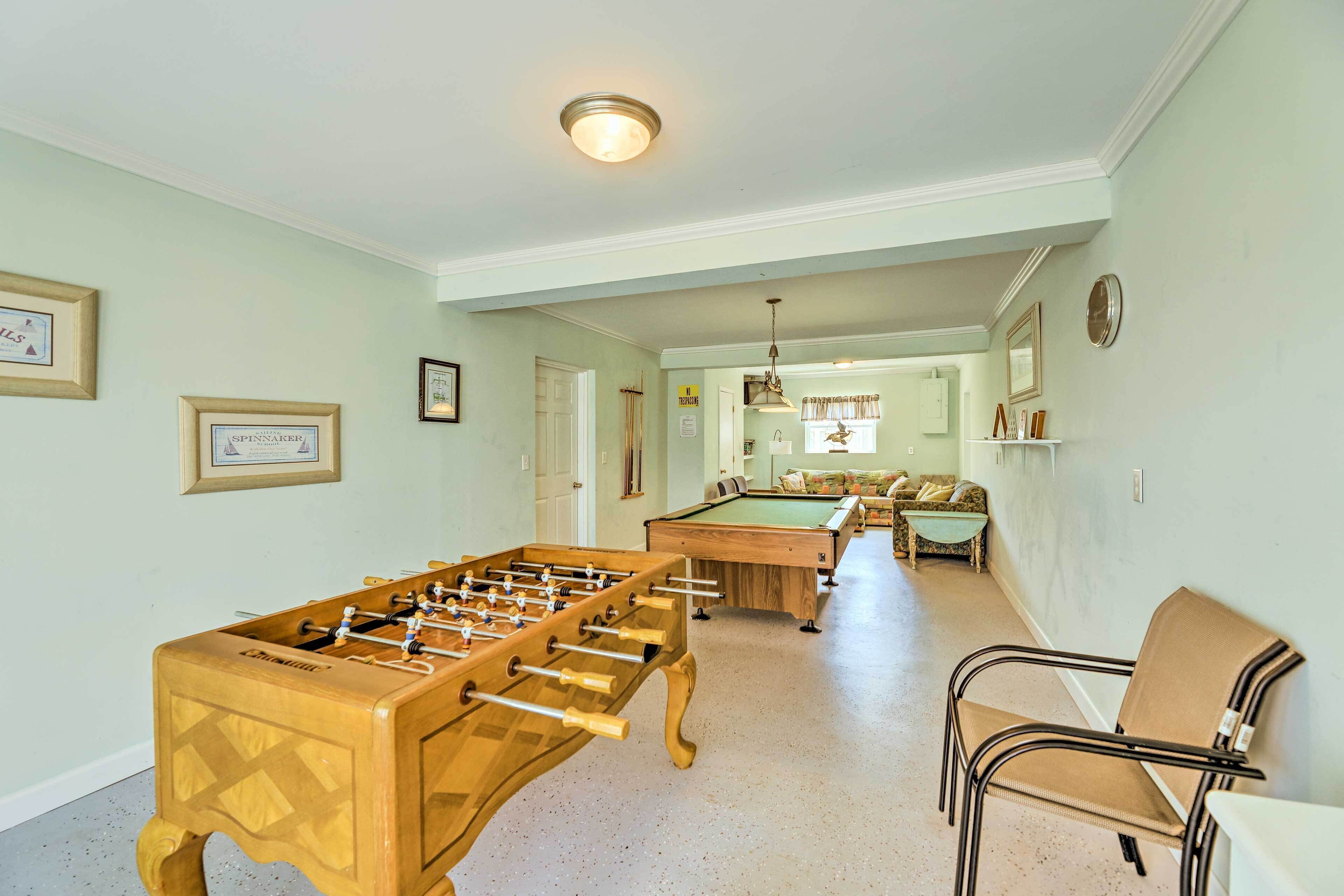 Una habitación amplia con mesa de futbolín, mesa de billar y una zona de estar confortable.
