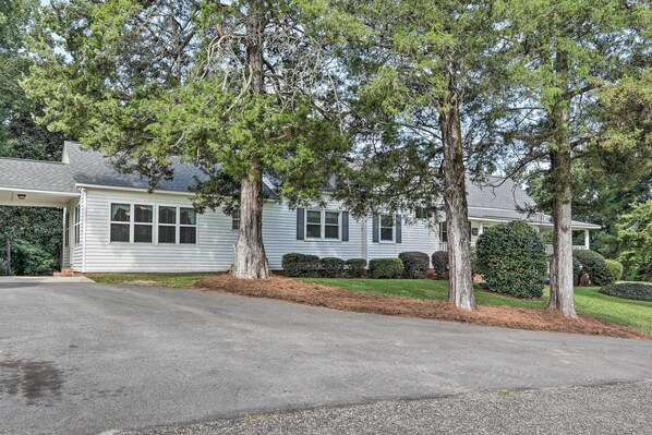 A two-story house with a covered front porch, a driveway, and mature trees. - Family Home w/ Fire Pit, 2 Mi to Lake Access (Lexington)