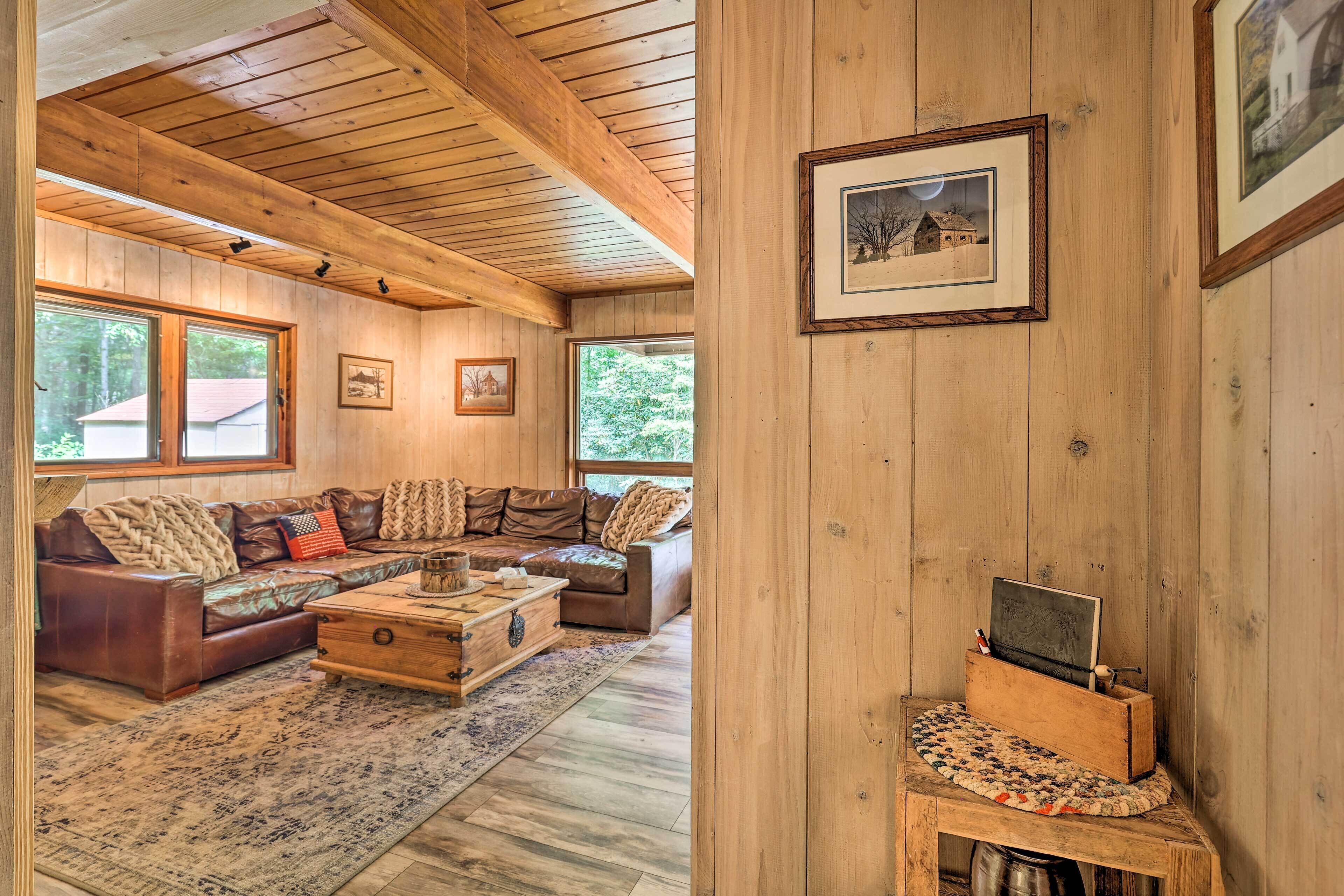 A wooden interior with a sectional sofa, a coffee table, and a framed picture on the wall.