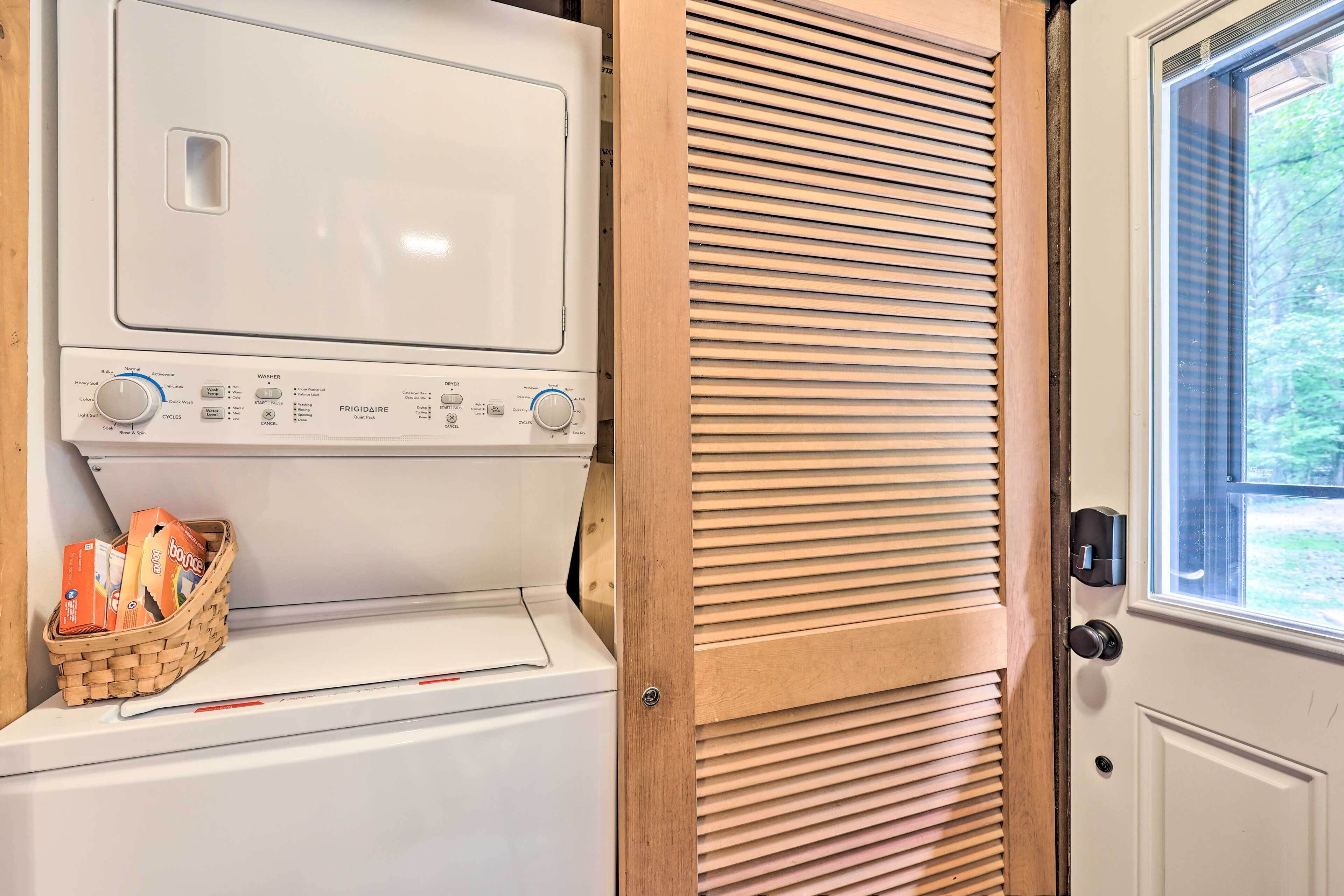 A compact washer and dryer unit with a control panel, a basket of items, and a door with a window view.