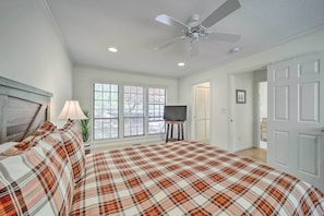 A bedroom with a plaid bedspread, a ceiling fan, a TV on a stand, and a window with blinds. - Scenic Sapphire Condo w/ Deck + Gas Grill! (Sapphire)
