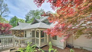 A house with a stone foundation, a covered porch, and a small garden area with mulch and plants. - Scenic Sapphire Condo w/ Deck + Gas Grill! (Sapphire)