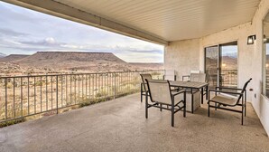 A covered balcony with a table and chairs, overlooking a desert landscape with a mountain in the distance. - Mtn-view Resort Condo, 5 Mi to Dtwn St George (St. George)