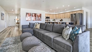 A modern living room with a grey sectional sofa, round ottomans, and abstract wall art. - Mtn-view Resort Condo, 5 Mi to Dtwn St George (St. George)