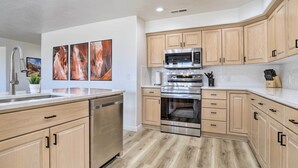 A modern kitchen with wooden cabinets, stainless steel appliances, and a central island. - Mtn-view Resort Condo, 5 Mi to Dtwn St George (St. George)