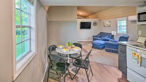 A compact living space with a dining area, a sofa, a TV, and a kitchenette. - Quaint Montezuma Cabin Near Lake Ponderosa! (Montezuma)