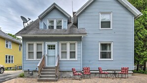 A two-story house with a front porch, a satellite dish, and a set of outdoor chairs. - Walkable Lake Elkhart Apt: Dine, Shop, Swim! (Elkhart Lake)