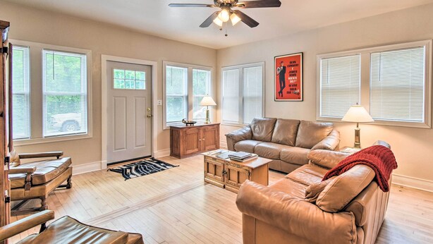 A spacious living room with a leather sofa, a coffee table, and a ceiling fan. - Walkable Lake Elkhart Apt: Dine, Shop, Swim! (Elkhart Lake)