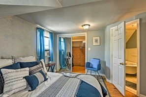 A bedroom with a bed, a chair, a door leading to a bathroom, and a hallway. - Cozy and Private Rental Unit in Towson/baltimore (Baltimore)