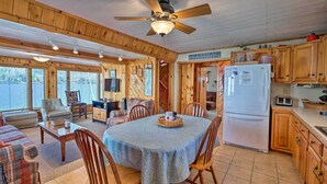 Un intérieur de chalet chaleureux comprenant un coin repas, une cuisine et un salon.
