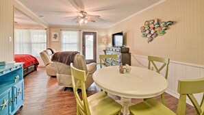 A dining area with a round table, green chairs, and a ceiling fan. - Rockport Bayfront Studio w/ Patio: 'casa Familia' (Rockport)