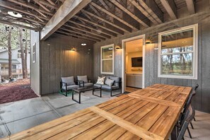 Une vaste terrasse dotée d’une table et de chaises en bois, d’un canapé et d’une petite table basse.