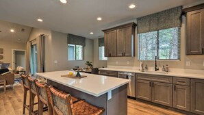 Una cocina moderna con una isla grande, taburetes de madera y armarios empotrados.