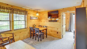 A wooden cabin interior with a dining table, chairs, a TV, and a 'WELCOME' sign. - Lake Pleasant Cabin on 3 Acres w/ Private Beach! (Speculator)