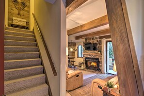 A staircase leading to a living area with a stone fireplace, a sofa, and a wooden ceiling. - Rustic Banner Elk Getaway ~ 1 Mi to Sugar Mountain (Banner Elk)